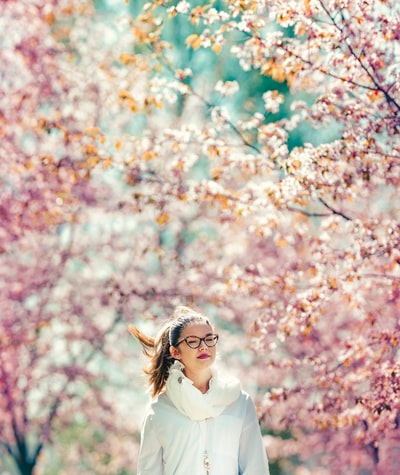 站在粉红色樱桃树上的女人